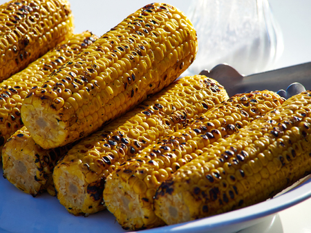 Fresh roasted or grilled corn cobs for sale in a food market