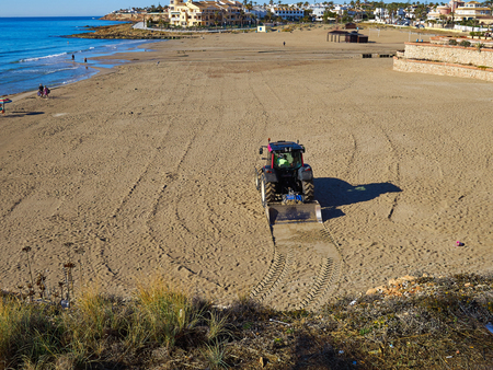 Popular great summer vacation travel destination La Zenia Beach being cleaned Orihuela Costa South Spainの写真素材