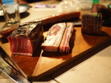 Whole block of Smoked Slab Bacon on a rustic wooden tray