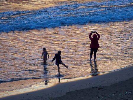 Happy family taking selfie and having fun on the beach summer fun by the sunset on vacation in Cyprusの写真素材