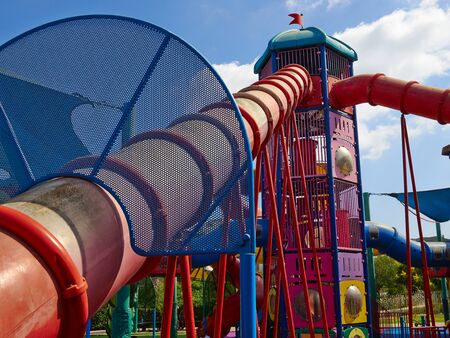 Colorful creative playground with several slides in different directions in a city park park