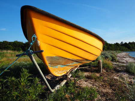 Small dingy boat on a trailer standing by the sea ocean shore and ready for action - boating sailing background imageの写真素材