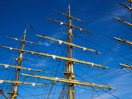 Sailing masts of traditional vintage wooden tallships sky background