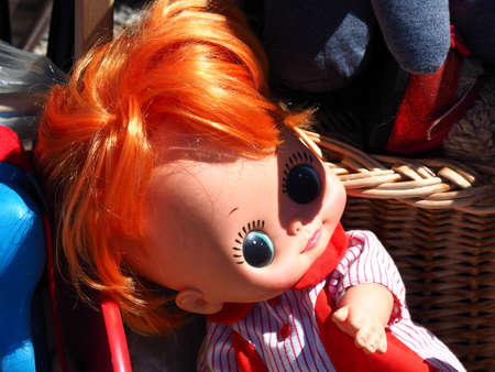 Cute classical red head children play doll on display in a flea market