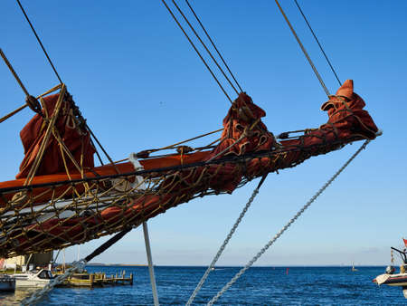 Bowsprit with the Danish flag and gathered sail of a large classical traditional vintage tall sailing shipの写真素材