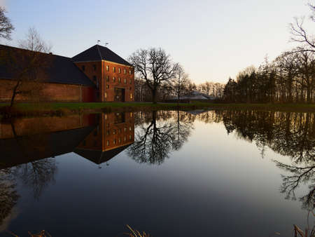 Agriculture farm mansion house reflection in a calm  lake in Funen Denmarkのeditorial素材