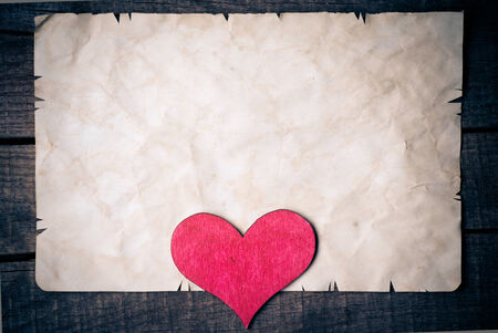 Wooden heart on old paperの写真素材