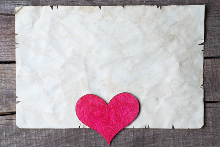 Wooden heart on old paperの写真素材