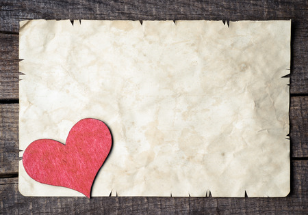Wooden heart on old paperの写真素材