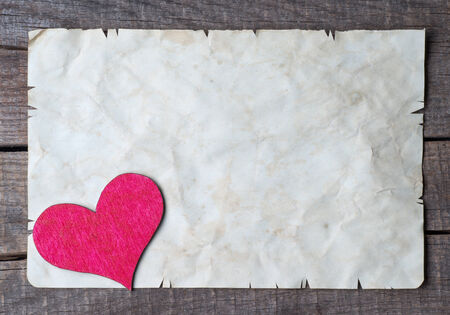 Wooden heart on old paperの写真素材