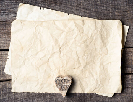 Wooden heart on old paper の写真素材