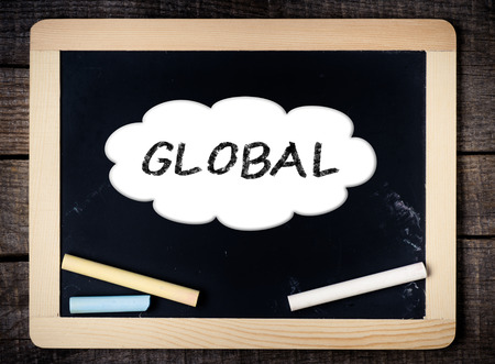 Global Concept inside cloud on blackboard on wood background の写真素材