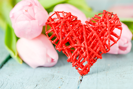 Red heart and tulips on wooden boardの写真素材