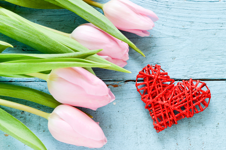 Red heart and tulips on wooden boardの写真素材