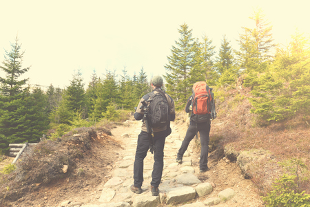 Hiking people with backpacks in mountainsの写真素材
