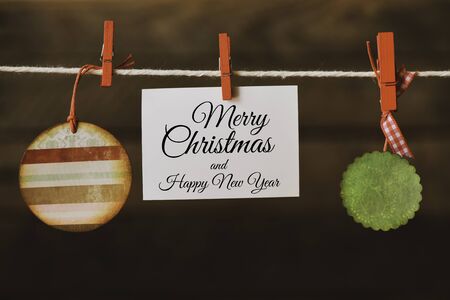 Merry Christmas inscription on a sheet of paper hung on a rope and Christmas decorations. Christmas time - concept. High resolution image.の写真素材