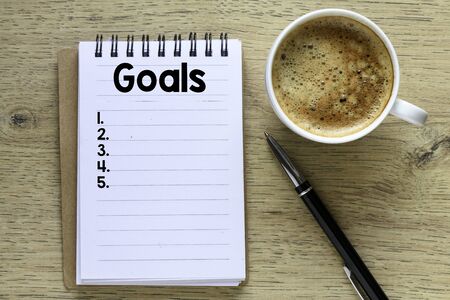 Goals text in the notebook on a wooden table. Top view - business conceptの写真素材