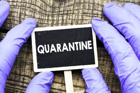 COVID-19 QUARANTINE word on black card and black background.の写真素材