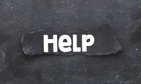 HELP. Word HELP written on a piece of black paper. Economic crisis concept.の写真素材