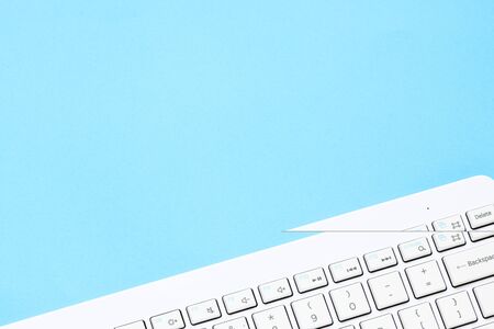 Close up white computer keyboard on blue background. View from above.
の写真素材