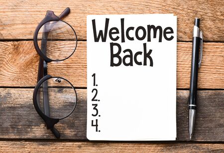 WELCOME BACK lettering written on notepad. Business concept.の写真素材