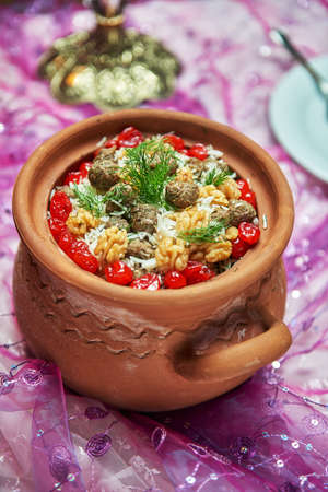 Azerbaijani national pilaf rice cooked in a clay pot with meat and herbs and cherry walnuts studio shotの写真素材