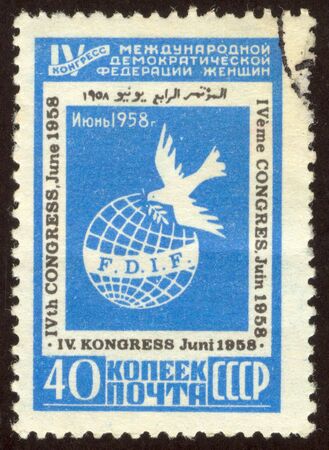 The scanned stamp. The Soviet stamp. The pigeon of the world flies over the earth.の写真素材