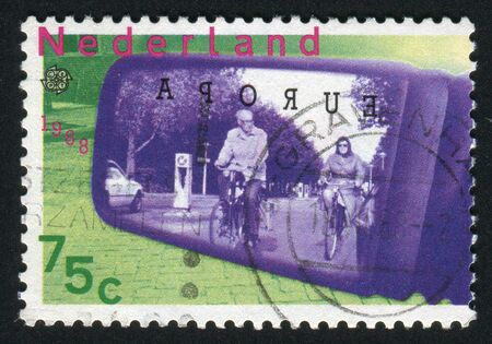 NETHERLANDS - CIRCA 1988: Modern transportation meeting ecological requirements. Cyclists seen through car-door mirror, circa 1988.のeditorial素材