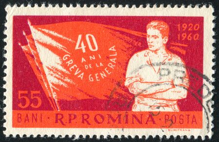 ROMANIA - CIRCA 1960: stamp printed by Romania, shows Worker and Flags, circa 1960のeditorial素材
