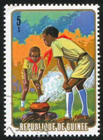 GUINEA CIRCA 1974: stamp printed by Guinea, shows Cooking in camp, circa 1974の写真素材