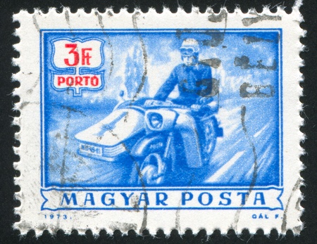 HUNGARY - CIRCA 1973: stamp printed by Hungary, shows mailman on motorbike, circa 1973の写真素材