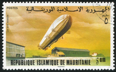 MAURITANIA - CIRCA 1976: stamp printed by Mauritania, shows Zeppelin over Hangar, circa 1976の写真素材