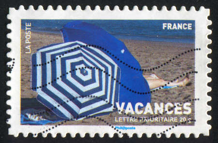 FRANCE - CIRCA 2007: stamp printed by France, shows beach umbrellas and woman, circa 2007の写真素材