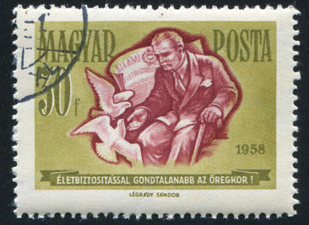HUNGARY â CIRCA 1958: stamp printed by Hungary, shows old man feeding pigeons, circa 1958のeditorial素材
