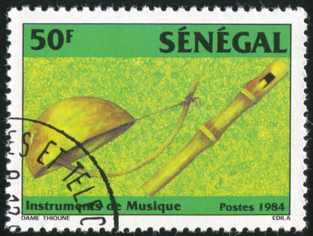 SENEGAL - CIRCA 1985: stamp printed by Senegal, shows Gourd fiddle, bamboo flute, circa 1985の写真素材