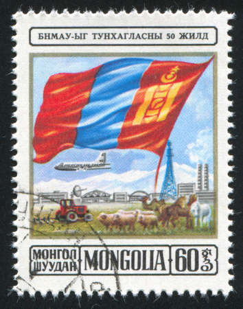 MONGOLIA - CIRCA 1974: stamp printed by Mongolia, shows flag over landscape, plane and communications tower, circa 1974の写真素材