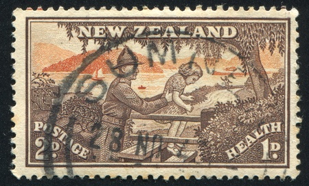 NEW ZEALAND - CIRCA 1945: stamp printed by New Zealand, shows Soldier Helping Child over Stile, circa 1945のeditorial素材