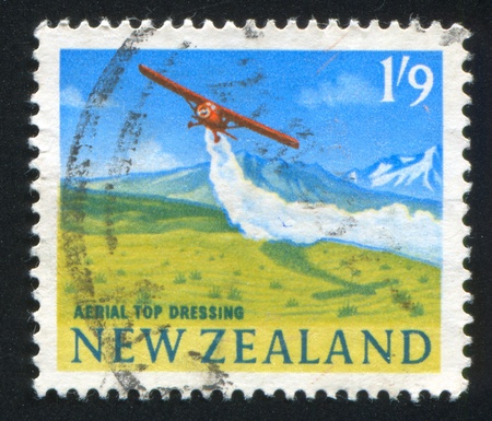 NEW ZEALAND - CIRCA 2001: stamp printed by New Zealand, shows Airplane Dispersing Agricultural Chemicals From Air, circa 2001の写真素材