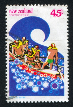 NEW ZEALAND - CIRCA 1982: stamp printed by New Zealand, shows Life-saving Crew Surfing, circa 1982のeditorial素材
