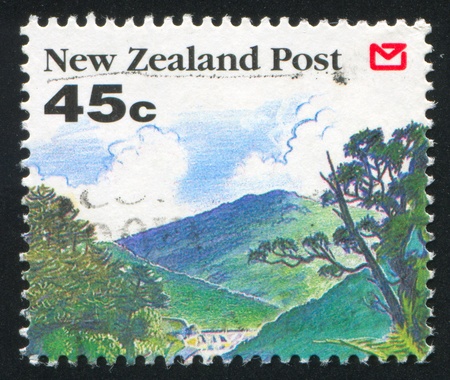 NEW ZEALAND - CIRCA 1992: stamp printed by New Zealand, shows Scenic Views of New Zealand, Trees, green hills, circa 1992の写真素材
