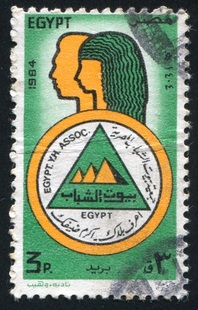 EGYPT - CIRCA 1984: stamp printed by Egypt, shows Youth Hostels association Emblem, Male and female figures, circa 1984の写真素材