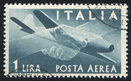 ITALY - CIRCA 1945: stamp printed by Italy, shows Plane and Clasped Hands, circa 1945のeditorial素材
