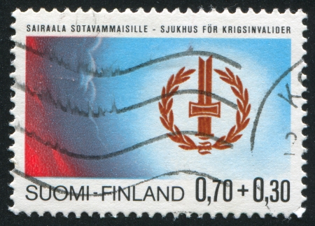 FINLAND - CIRCA 1976: stamp printed by Finland, shows Badge of the War Invalids Association, circa 1976のeditorial素材