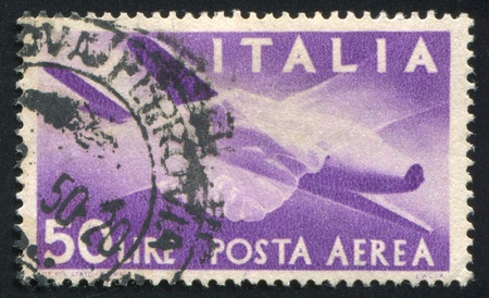ITALY - CIRCA 1945: stamp printed by Italy, shows Plane and Clasped Hands, circa 1945のeditorial素材