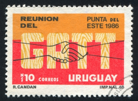 URUGUAY - CIRCA 1986: stamp printed by Uruguay, shows General Agreement on Tariffs and Trade Committee Meeting, Punta del Este, circa 1986のeditorial素材
