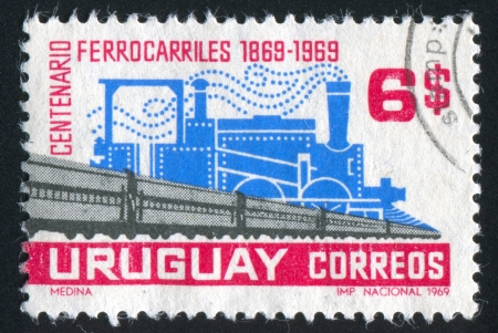 URUGUAY - CIRCA 1969: stamp printed by Uruguay, shows Old Steam Locomotive and Modern Railroad Cars, circa 1969のeditorial素材