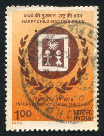 INDIA - CIRCA 1979: stamp printed by India, shows emblem and children, circa 1979のeditorial素材