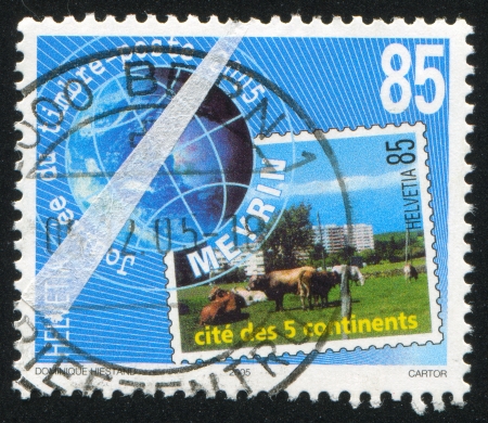 SWITZERLAND - CIRCA 2005: stamp printed by Switzerland, shows cow and city, circa 2005のeditorial素材