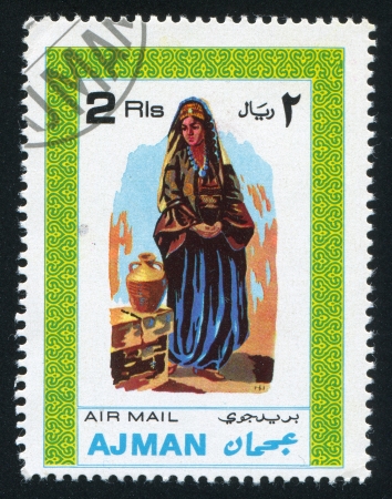 AJMAN - CIRCA 1976: stamp printed by Ajman, shows a Woman and a Jar, circa 1976のeditorial素材