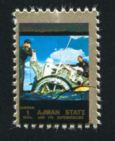 AJMAN - CIRCA 1976: stamp printed by Ajman, shows Spaceship landing, circa 1976のeditorial素材